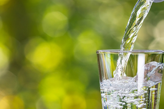 Drinking water being poured into a clear glass